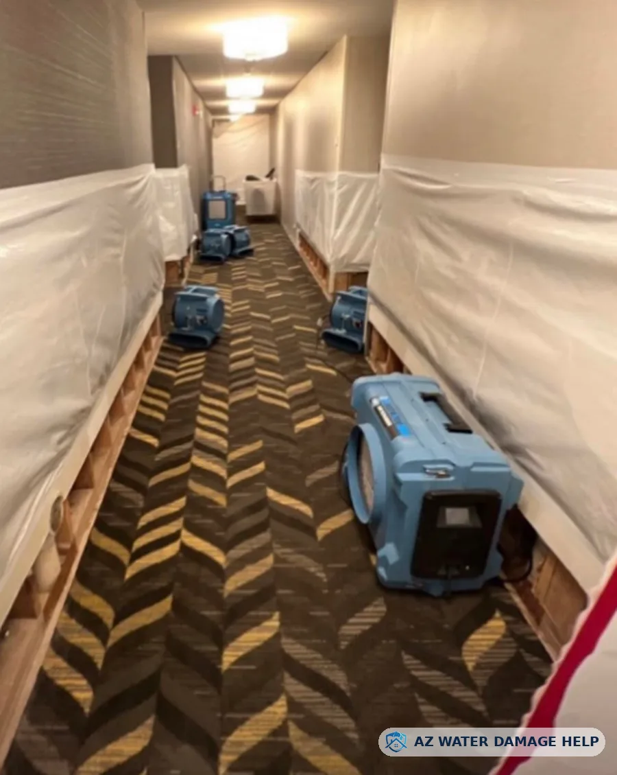 Commercial hallway with wall containment and air movers drying carpet