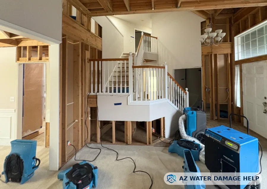 Flood-cut drywall and air movers drying a two-story home after water damage
