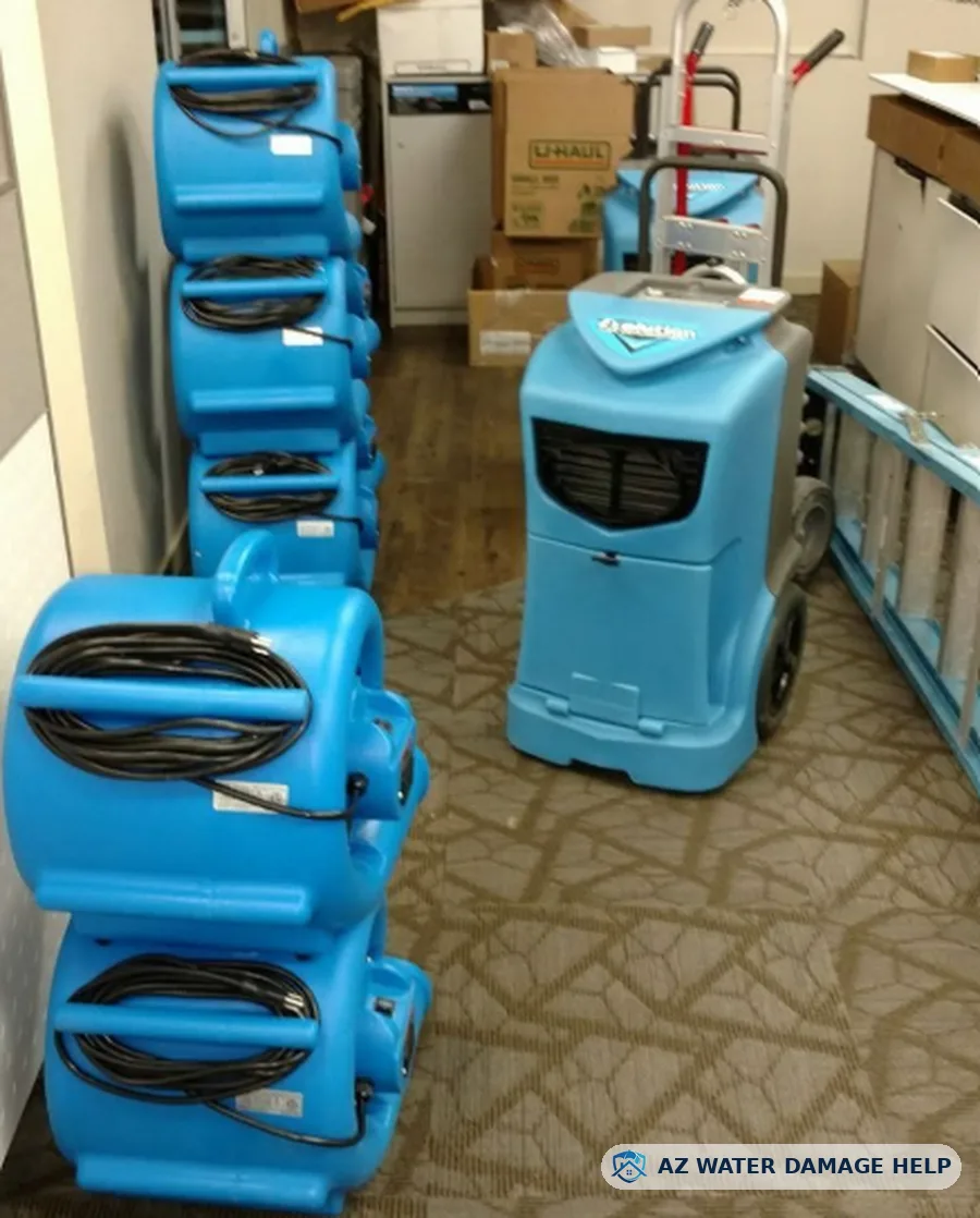 Stacked air movers and a commercial dehumidifier ready for a water damage job